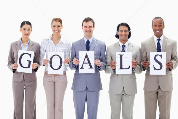 Stock photo: Happy business team holding the letters of GOALS against white background