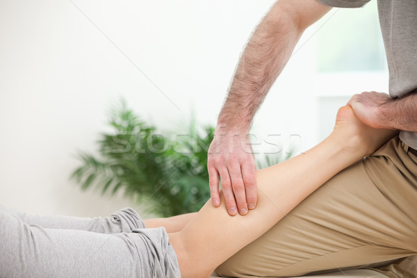 Physiotherapist pressing a leg with his fingers in a room Stock photo © wavebreak_media