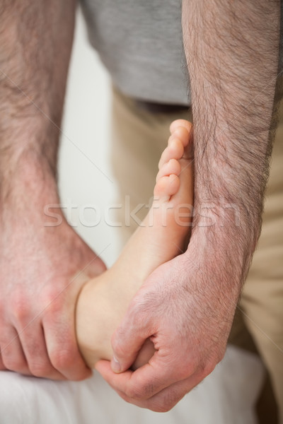 Doctor making a joint mobilisation on the ankle of a woman in a room Stock photo © wavebreak_media