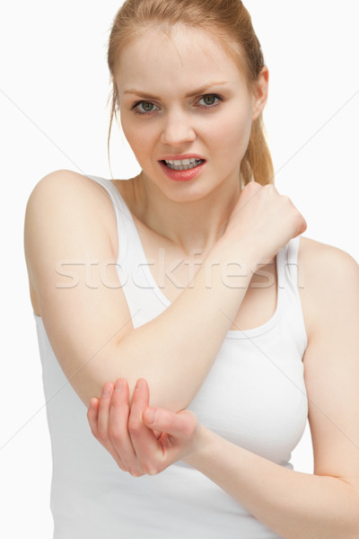Blonde woman touching her painful elbow against white background Stock photo © wavebreak_media