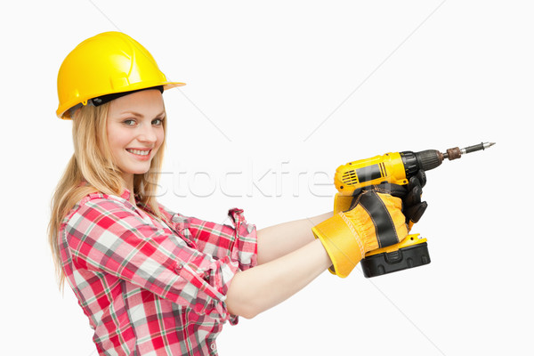 Smiling woman using an electric screwdriver against white background Stock photo © wavebreak_media