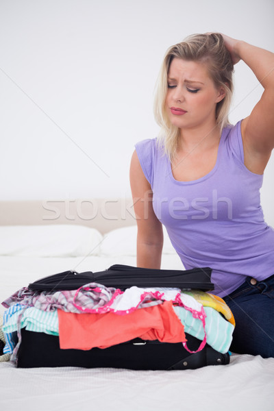 Young woman rubbing her head while looking at her full suitcase on her bed Stock photo © wavebreak_media