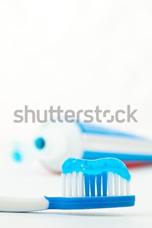 Tube of toothpaste next to a red toothbrush against white background Stock photo © wavebreak_media