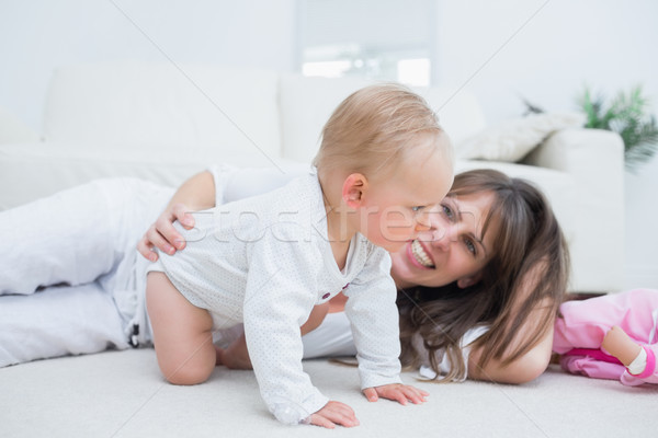 Baby on all fours next to his mother in living room Stock photo © wavebreak_media