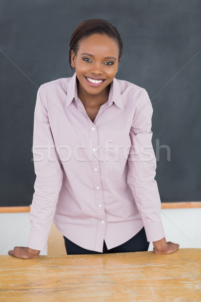 Teacher standing up while smiling in a classroom Stock photo © wavebreak_media