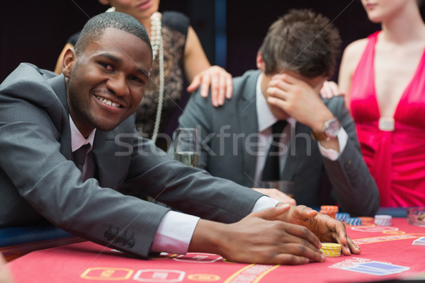 Man smiling while claiming jackpot in poker game in casino Stock photo © wavebreak_media