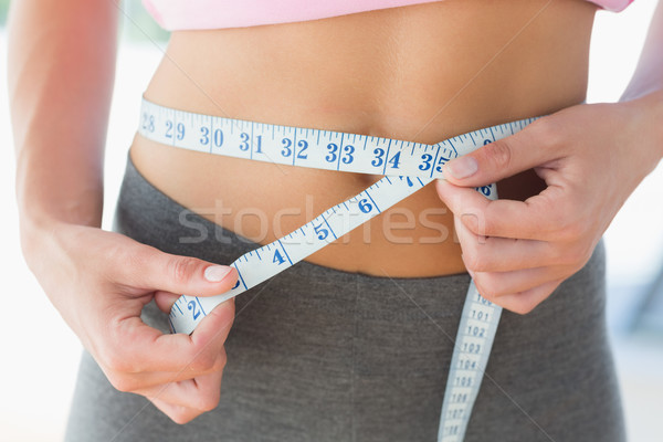 Woman measuring waist in fitness studio Stock photo © wavebreak_media