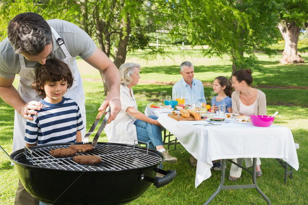 Foto stock: Hijo · de · padre · parrilla · de · la · barbacoa · familia · almuerzo · familia · ampliada · parque