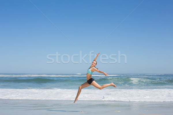 Fit woman jumping gracefully on the beach  Stock photo © wavebreak_media