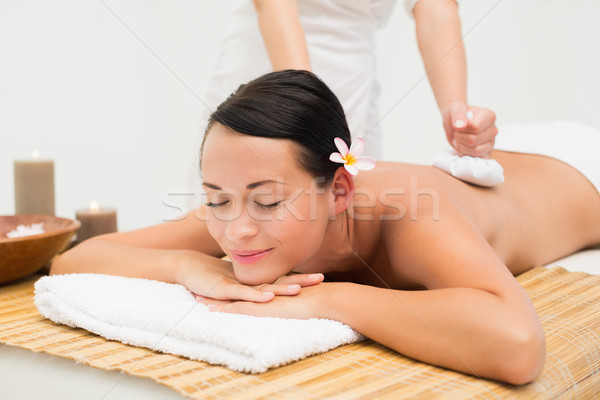 Peaceful brunette enjoying a herbal compress massage  Stock photo © wavebreak_media
