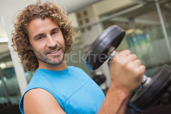 Handsome man exercising with dumbbell in gym Stock photo © wavebreak_media