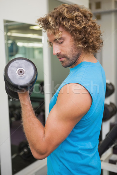 Handsome man exercising with dumbbell in gym Stock photo © wavebreak_media