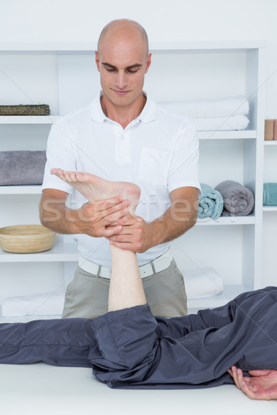 Physiotherapist doing leg massage to his patient Stock photo © wavebreak_media
