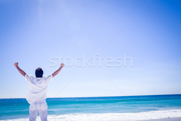 Man stretching his arms in front of the sea Stock photo © wavebreak_media