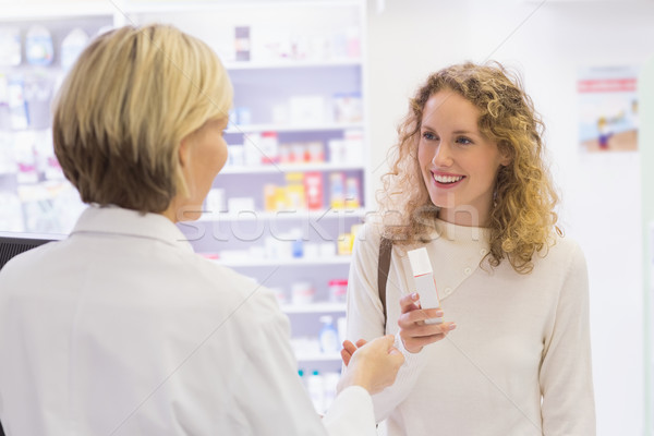 Costumer showing medicine jar to pharmacist  Stock photo © wavebreak_media