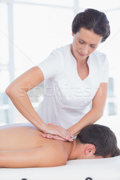 Stock photo: Physiotherapist doing back massage to her patient