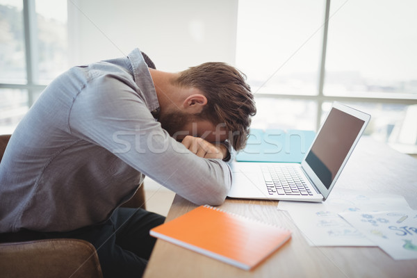 Tired executive leaning on desk Stock photo © wavebreak_media