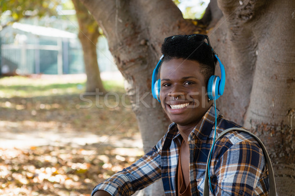Moço fones de ouvido ouvir música parque retrato música Foto stock © wavebreak_media