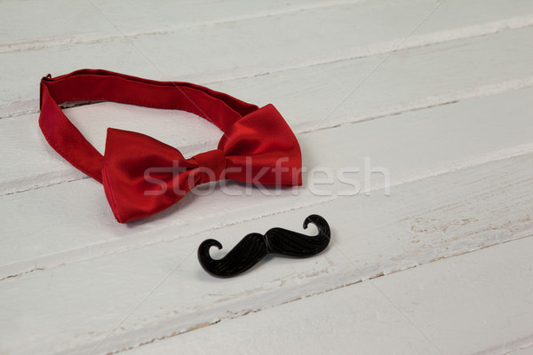 Stock photo: Bow tie and fake moustache arranged on wooden plank