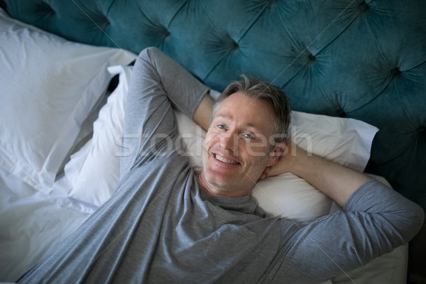 Smiling man sleeping on bed in bedroom Stock photo © wavebreak_media