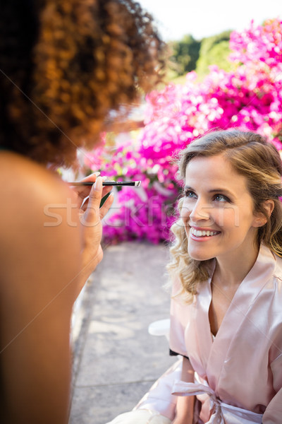 Woman applying makeup to bride in yard Stock photo © wavebreak_media