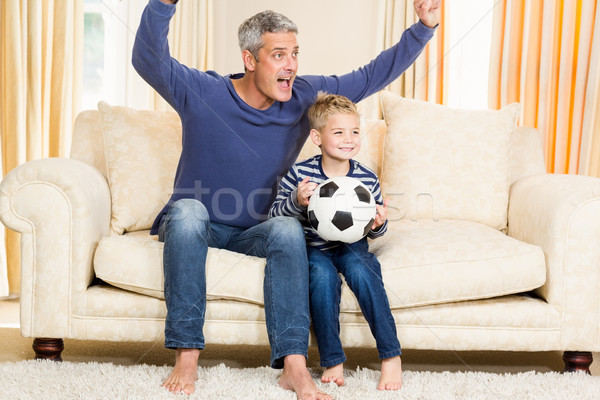 Stock photo: Father and son exulting on the sofa