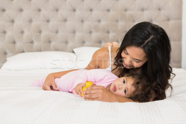 Brunette spelen baby eend bed liefde Stockfoto © wavebreak_media