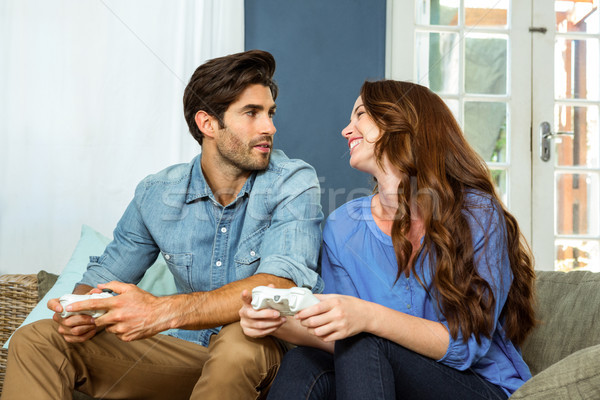 Young couple playing video game while sitting on sofa Stock photo © wavebreak_media