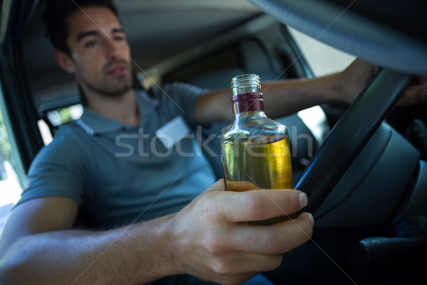 Om alcool sticlă conducere maşină Imagine de stoc © wavebreak_media