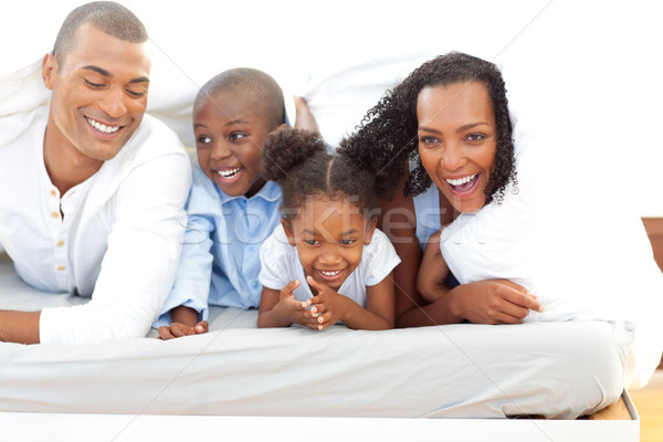 Lively family having fun lying down on bed Stock photo © wavebreak_media