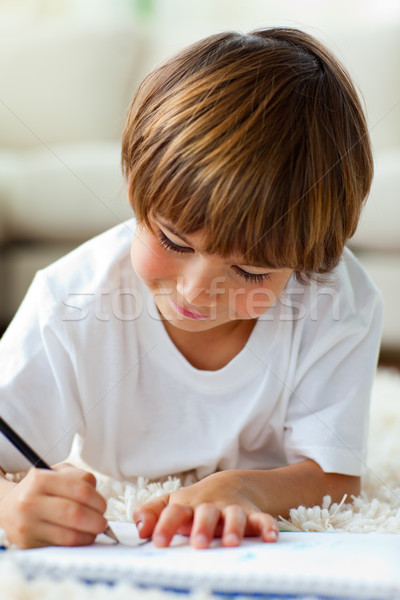 Jolly little boy drawing lying on the floor Stock photo © wavebreak_media