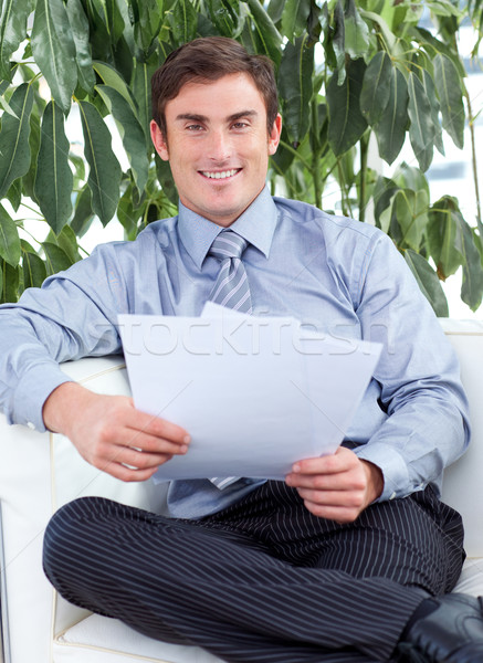 Stock photo: Businessman reading papers and smiling at the camera