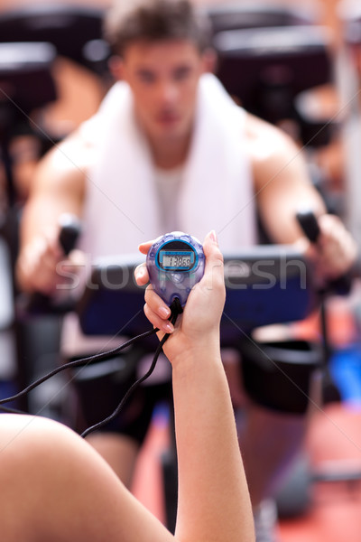 Woman holding a chronometer and man doing physical exercise Stock photo © wavebreak_media