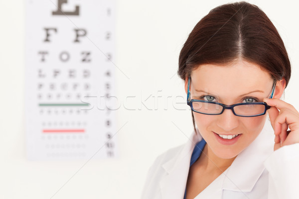 A female optician with glasses and eye test in her office Stock photo © wavebreak_media