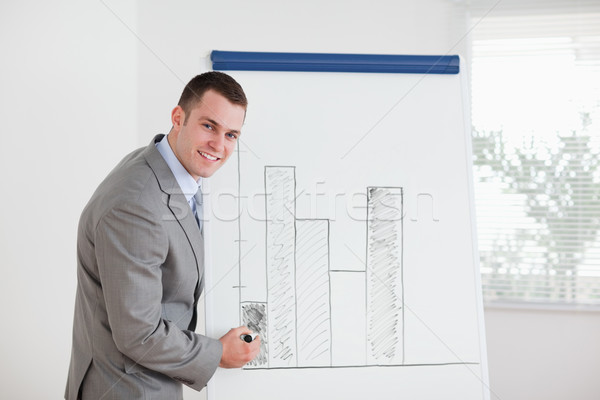 Smiling young businessman editing column graph Stock photo © wavebreak_media