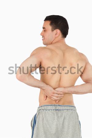 Young male experiencing back pain against a white background Stock photo © wavebreak_media