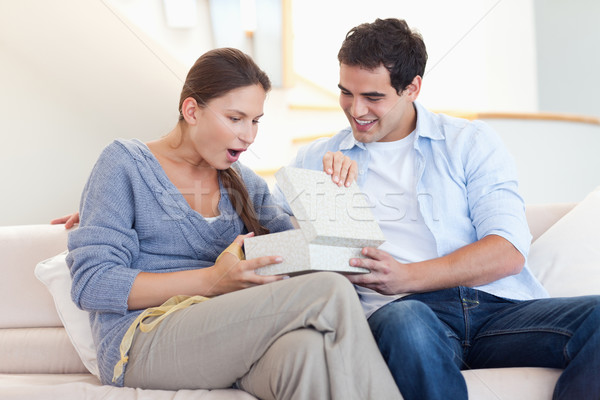 Stock photo: Man offering a present to his wife in their living room