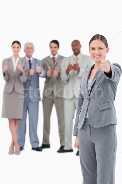 Saleswoman with thumb up and her team behind her against a white background Stock photo © wavebreak_media