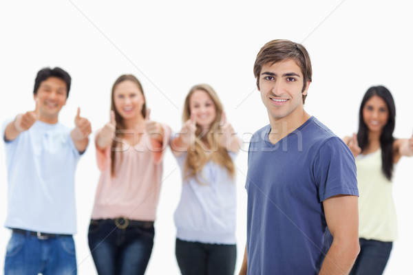 Man smiling with people approving behind him against white background Stock photo © wavebreak_media