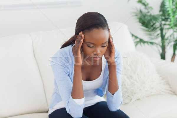 Black woman holding her head in a living room Stock photo © wavebreak_media
