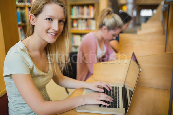 Diák felfelé néz laptop mosolyog főiskola könyvtár Stock fotó © wavebreak_media