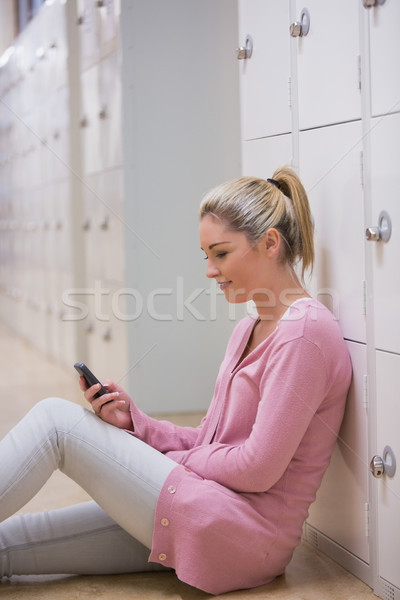 Mosolygó nő ül főiskola folyosó sms chat diák Stock fotó © wavebreak_media
