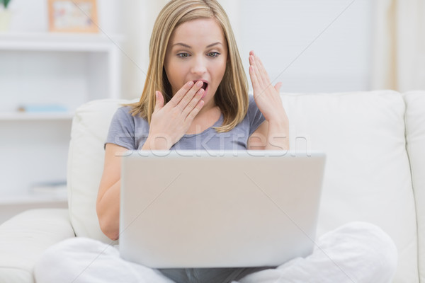 étonné femme utilisant un ordinateur portable maison jeune femme [[stock_photo]] © wavebreak_media
