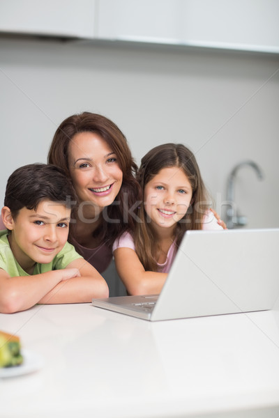 Uśmiechnięty matka dzieci za pomocą laptopa kuchnia portret Zdjęcia stock © wavebreak_media