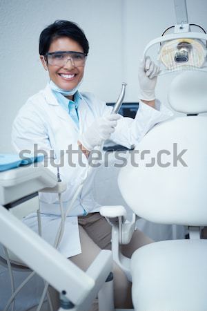 Dentysta uśmiechnięty kamery obok krzesło stomatologicznych Zdjęcia stock © wavebreak_media
