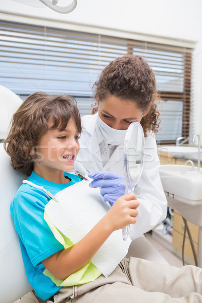 Stock photo: Pediatric dentist showing little boy his teeth in the mirror