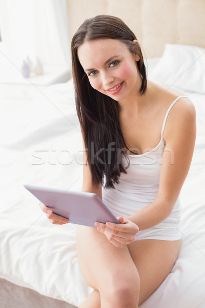 Pretty brunette using tablet pc on bed Stock photo © wavebreak_media