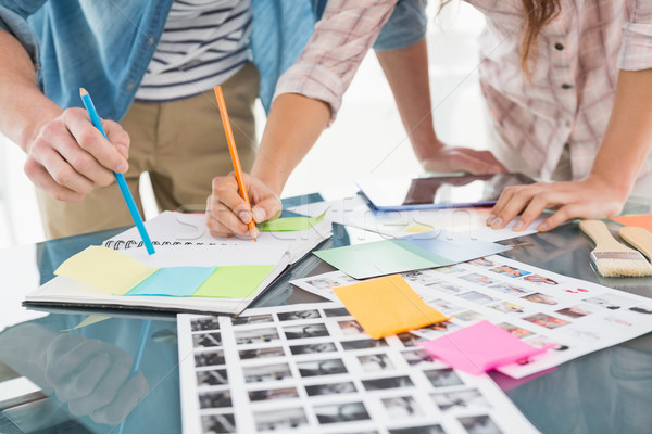 Stock photo: Colleagues writing notes and editing photos