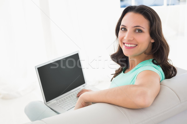 Brunetka za pomocą laptopa sofa domu salon komputera Zdjęcia stock © wavebreak_media