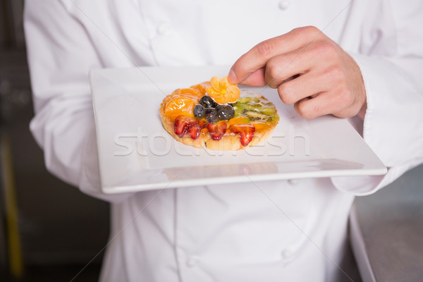 Close up of baker putting flower on the pastry with fruit Stock photo © wavebreak_media